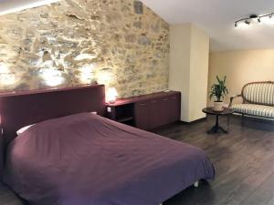 a bedroom with a bed and a stone wall at COEUR de GOUDARGUES! Gîte 2 ou 3 pers , Extérieur, Clim in Goudargues