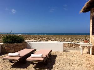 - une terrasse avec 2 tables de pique-nique et la plage dans l'établissement Spinguera Ecolodge, à Espingueira