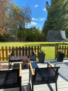 three benches on a deck with a wooden fence at Centrally located spacious Townhouse with large patios and a Fireplace in Boden