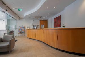 a large waiting room with a large wooden reception desk at 206 Funky Executive Studio Cbd Ac in Perth