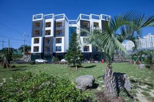 a palm tree in front of a building at Fellisia Hotel in Seogwipo