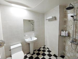 a white bathroom with a sink and a toilet at Fellisia Hotel in Seogwipo