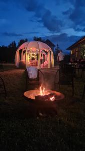 a fire pit in front of a tent at night at Hotel Restaurant Park in Miercurea-Ciuc