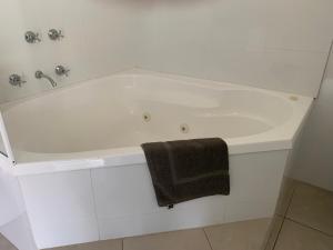a white bath tub with a towel on it at Orbost Country Man Motor Inn in Orbost