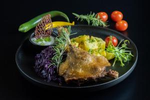 un plato de comida con carne y verduras en una mesa en Hotel Restaurant Park en Miercurea-Ciuc