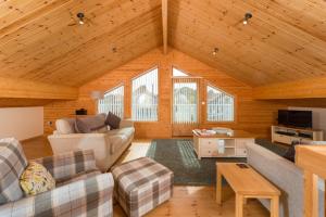 una sala de estar con sofás y techo de madera. en Finest Retreats - Puddleduck, en Fritton