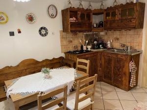 a kitchen with a table and chairs and a sink at Árpád nyaralóház in Sarud