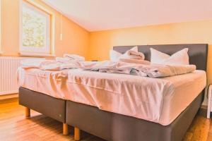 a bed with pink sheets and white pillows on it at mit Meerblick und Balkon, gratis Nutzung vom AHOI Erlebnisbad und Sauna in Sellin - Meeresblick FeWo 29 in Göhren +14 photos
