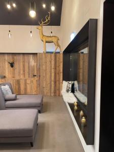 a living room with a couch and a deer head on the wall at Das Liftplatzl in Sankt Michael im Lungau