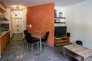 a kitchen and dining room with a table and a tv at Darling Apartman in Szeged