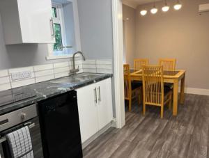 a kitchen with a sink and a table with chairs at Beautiful 2 Bed Apt with Hot Tub in Blaydon Burn in Blaydon
