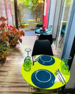 a yellow table with plates on it on a patio at Moya Résidence by MD in Dzaoudzi