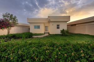 a house in a yard with a field of flowers at Airport Hotel in Abha