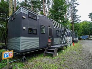 a large black trailer with a staircase next to it at 森と湖の楽園ＷorkshopＣampＲesort in Fujikawaguchiko