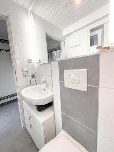 uma casa de banho branca com um lavatório e um WC em Ginius Homes - Eifelglück im Grünen em Kall