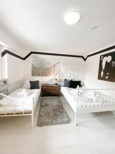 uma sala de estar com duas camas e um sofá em Ginius Homes - Eifelglück im Grünen em Kall
