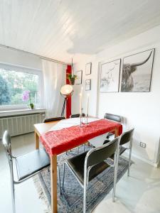 une salle à manger avec une table et des chaises rouges dans l'établissement Ginius Homes - Eifelglück im Grünen, à Kall