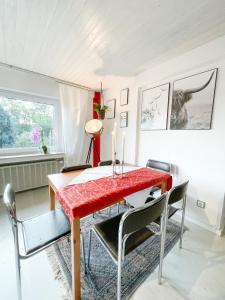 a dining room with a red table and chairs at Ginius Homes - Eifelglück im Grünen in Kall