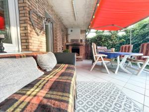 a patio with a couch and a table on a patio at Ginius Homes - Eifelglück im Grünen in Kall