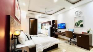 1 dormitorio con cama, escritorio y ordenador en ZEN Studios - DLF CyberCity Gurgaon en Gurgaon