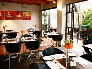 a restaurant with tables and chairs in a room at Court Classique Suite Hotel in Pretoria