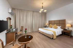 a hotel room with a large bed and a table at Airport Hotel in Abha +34 photos
