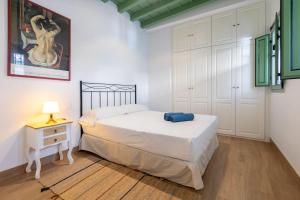 een slaapkamer met een bed en een nachtkastje met een lamp bij Charming apartment at La Alameda Seville City Center by Oui Sevilla in Sevilla