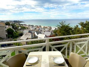 una mesa en un balcón con vistas al océano en Magnifique vue mer - Tout confort en Pléneuf-Val-André