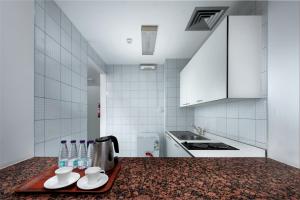 a kitchen counter with a tray of water bottles on it at Airport Hotel in Abha