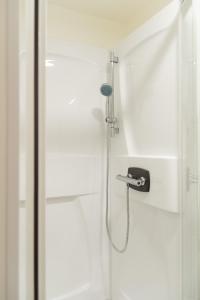 a shower in a bathroom with a shower head at Le Place Du Bourg Appartement T2 Centre Historique Rodez in Rodez