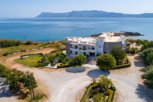 una vista aerea di una grande casa bianca con l'oceano di Elena Beach Hotel a Kíssamos