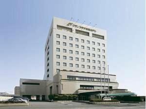 un edificio bianco con un parcheggio di fronte di Grand Plaza Nakatsu Hotel - Vacation STAY 28275v a Nakatsu