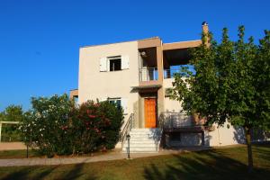 ein weißes Haus mit Treppen und einem Baum in der Unterkunft VILLA DIAMOND Κουρούτα Αμαλιαδος in Amaliada