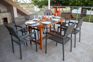 Une table et des chaises en bois sont disponibles sur la terrasse. dans l'établissement VILLA DIAMOND Κουρούτα Αμαλιαδος, à Amaliáda