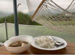 a plate of food on a table with a bowl of food at Casita Blanca Jala-Jala - Tiny House & Farm Stay in Jalajala
