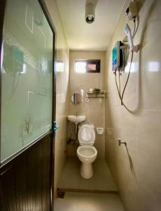 a small bathroom with a toilet and a shower at Casita Blanca Jala-Jala - Tiny House & Farm Stay in Jalajala