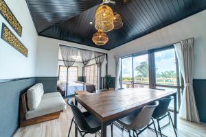 uma sala de jantar com uma mesa de madeira e cadeiras em Crystal Villa Imgya em Ilhas Miyako