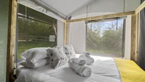a bedroom with a large bed with towels on it at The Herdwick Safari Tent in Hertford