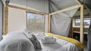 1 dormitorio con cama con dosel y ventana en Finest Retreats - The Herdwick Safari Tent, en Hertford