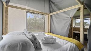 a bedroom with a canopy bed with a window at The Herdwick Safari Tent in Hertford
