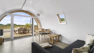 ein Wohnzimmer mit einem Sofa und einem Tisch in der Unterkunft Finest Retreats - The Highland Camping Pod in Hertford