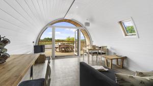 a living room with an arched window and a table at Finest Retreats - The Chicken Coop in Hertford