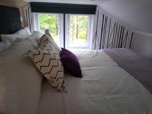 a large white bed with pillows and a window at The Cuddies in Balloch