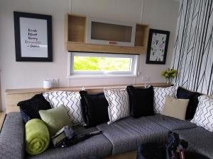 un soggiorno con divano, cuscini e finestra di The Cuddies a Balloch