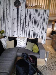 ein Wohnzimmer mit einem Sofa mit einer Spielsteuerung darauf in der Unterkunft The Cuddies in Balloch