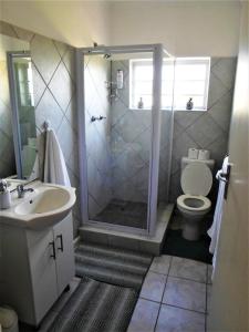 La salle de bains est pourvue d'une douche, de toilettes et d'un lavabo. dans l'établissement Cenikma Guest Suites - Couples Room, à East London