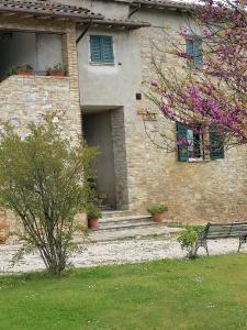 un edificio de piedra con un banco delante en Fattoria di Rigone, en Coltavolino