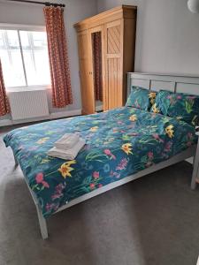 a bed with a blue bedspread with flowers on it at Victorian Building With Character in London