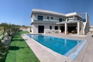a house with a swimming pool in front of it at וילה-ליה in Caesarea