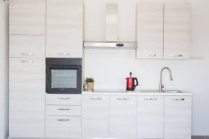 a kitchen with white cabinets and a microwave at וילה-ליה in Caesarea